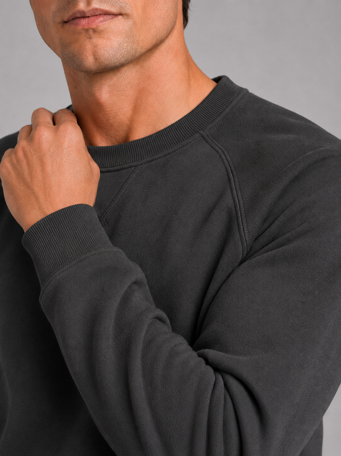 Close up of gray cotton sweater showing heavyweight knit fabric and classic crew neck detail
