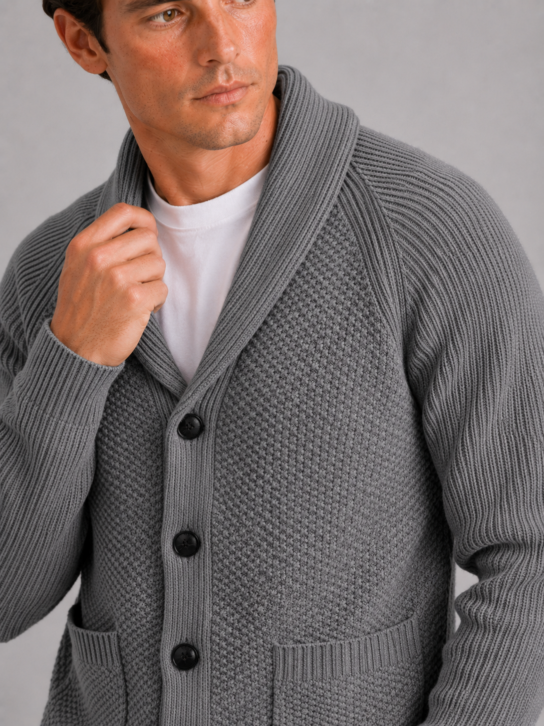 Close up of gray knit cardigan showing soft textured fabric and front pocket detail