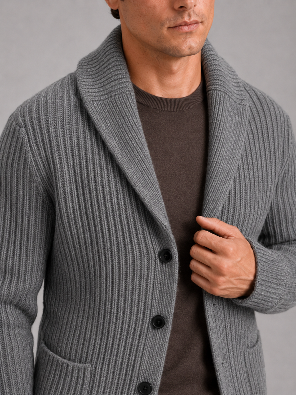 Close up of gray knit cardigan showing soft warm texture and refined lapel button detail