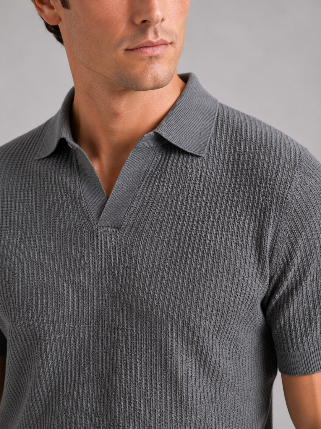 Close up of gray knit polo showing soft breathable fabric and refined collar detail
