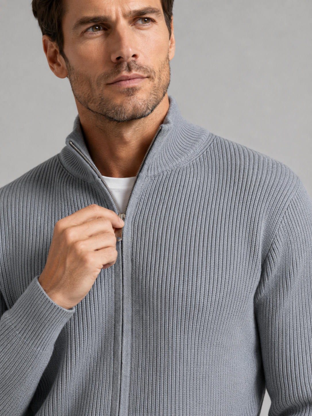 Close-up of a gray ribbed knit cardigan showing the textured knit fabric, stand collar, full zipper, ribbed cuffs, hem, and stitching details