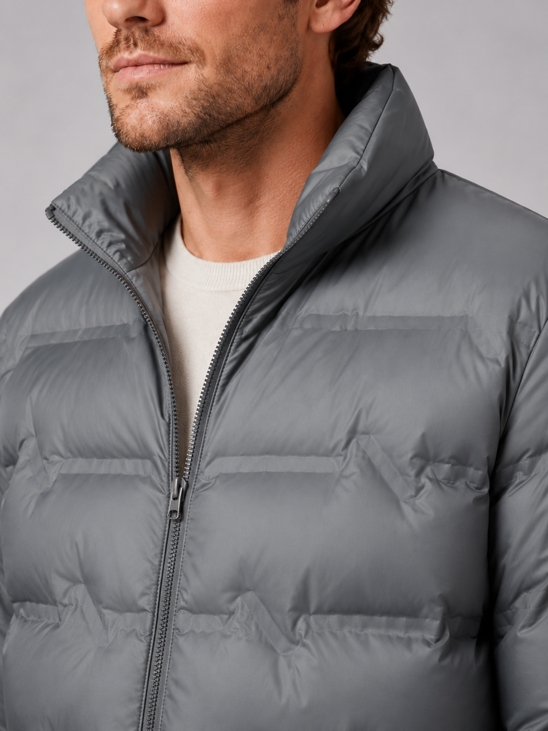Close up of gray white duck down jacket showing premium quilted insulation, stand collar, and weather resistant fabric detail
