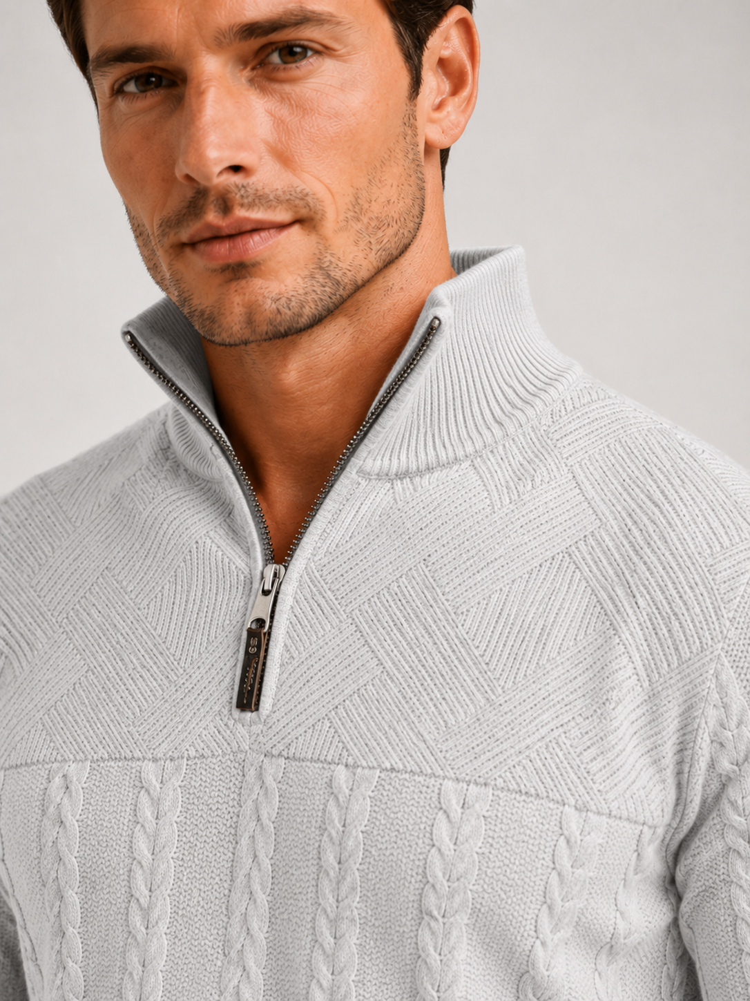 Close up of gray jacquard sweater showing textured knit pattern, quarter zip, and warm fabric detail