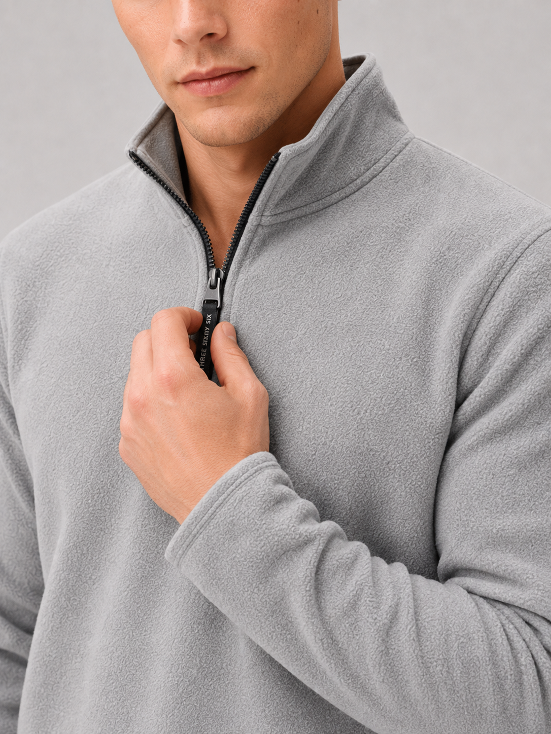 Close up of gray fleece pullover showing soft thermal fabric and quarter zip mock neck detail