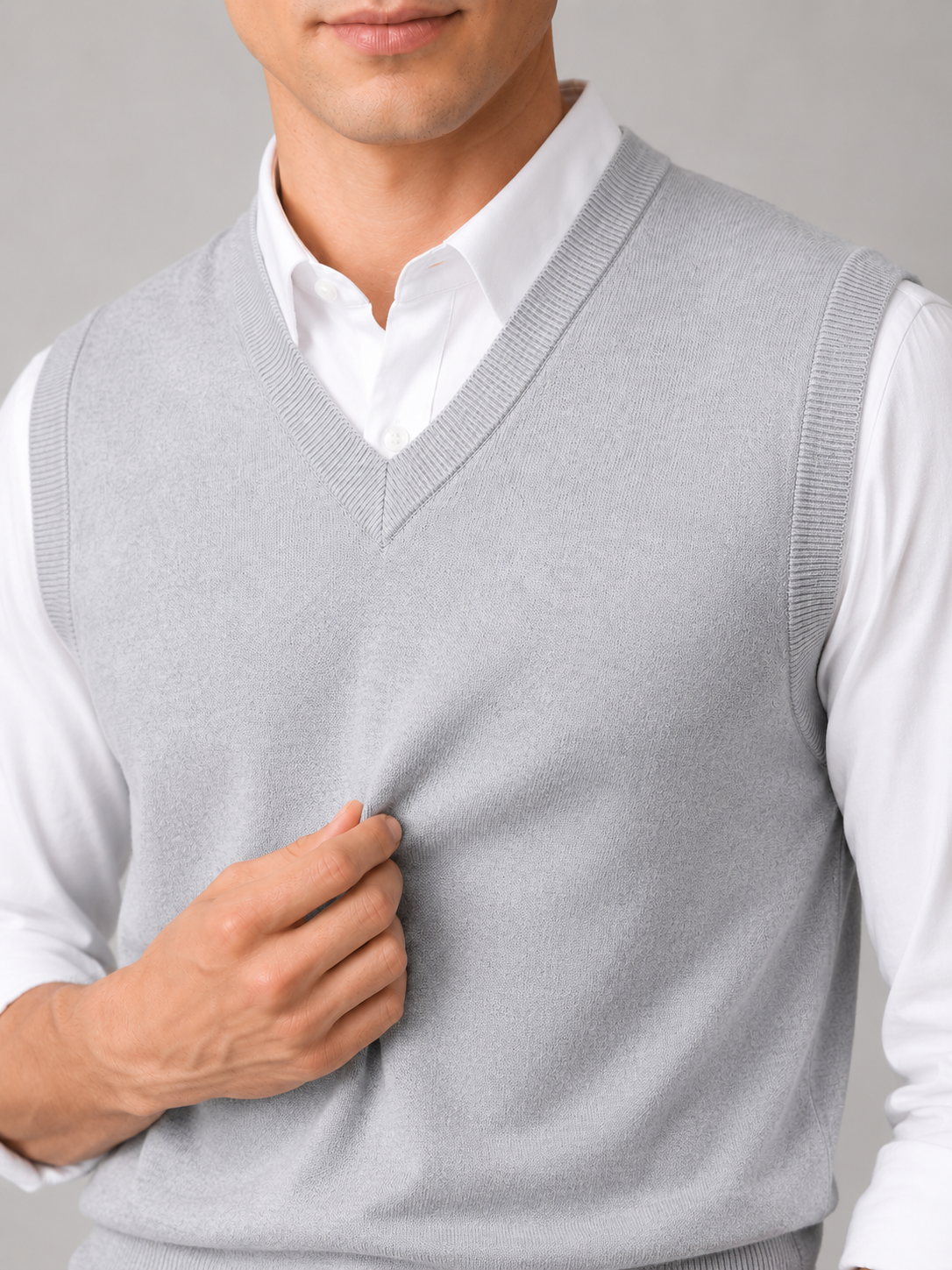 Close up of gray sweater vest showing soft knit texture and classic v neck detail