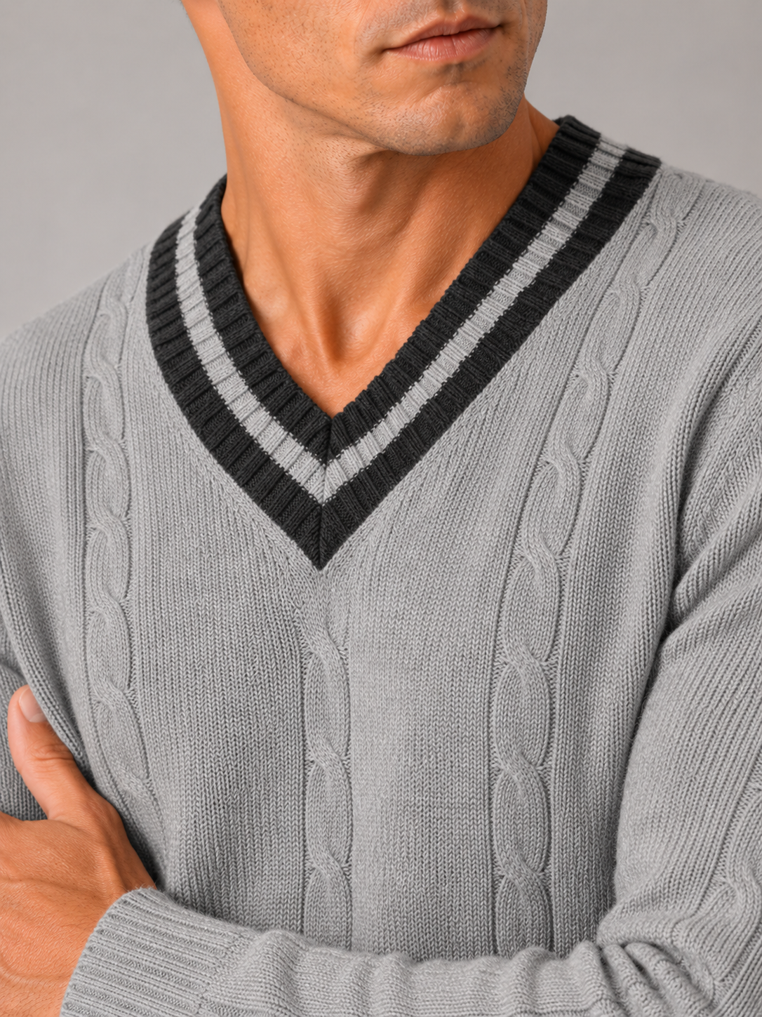 Close up of gray knit sweater showing soft warm fabric and refined v neck detail