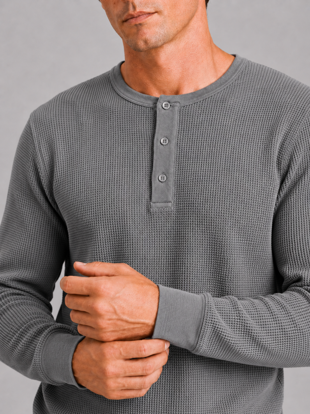 Close up of gray waffle knit henley showing breathable textured fabric and button detail
