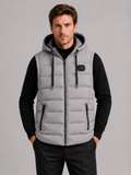 Front view of a man wearing a gray hooded puffer vest with cotton padding, thick insulation, sleeveless design, and full zip front