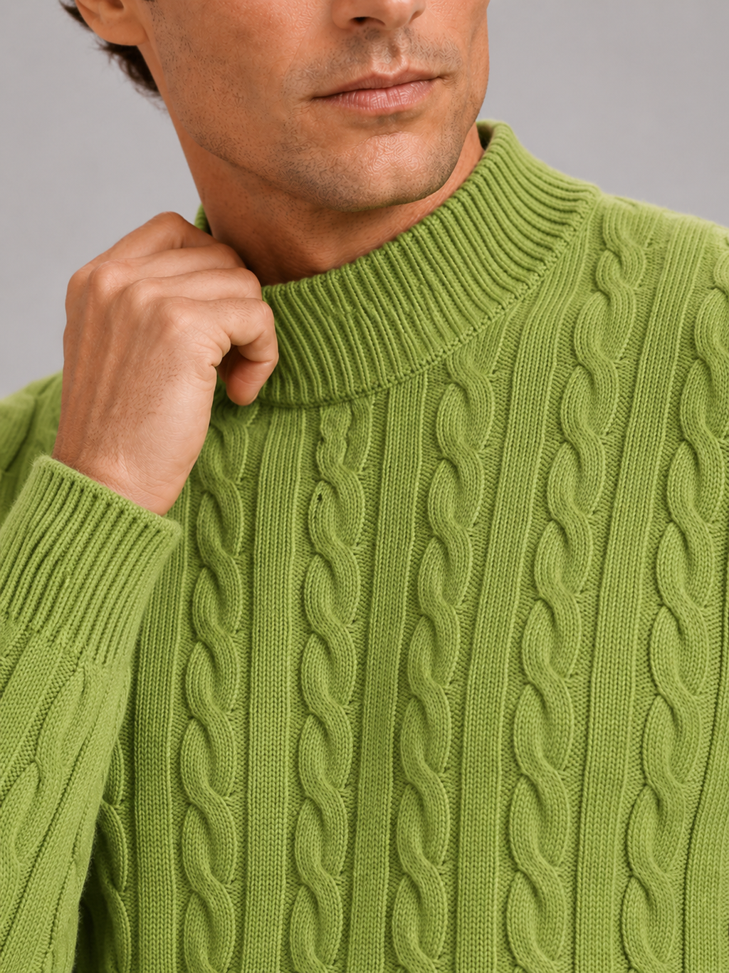 Close up of green wool cable knit sweater showing soft texture and mock neck detail