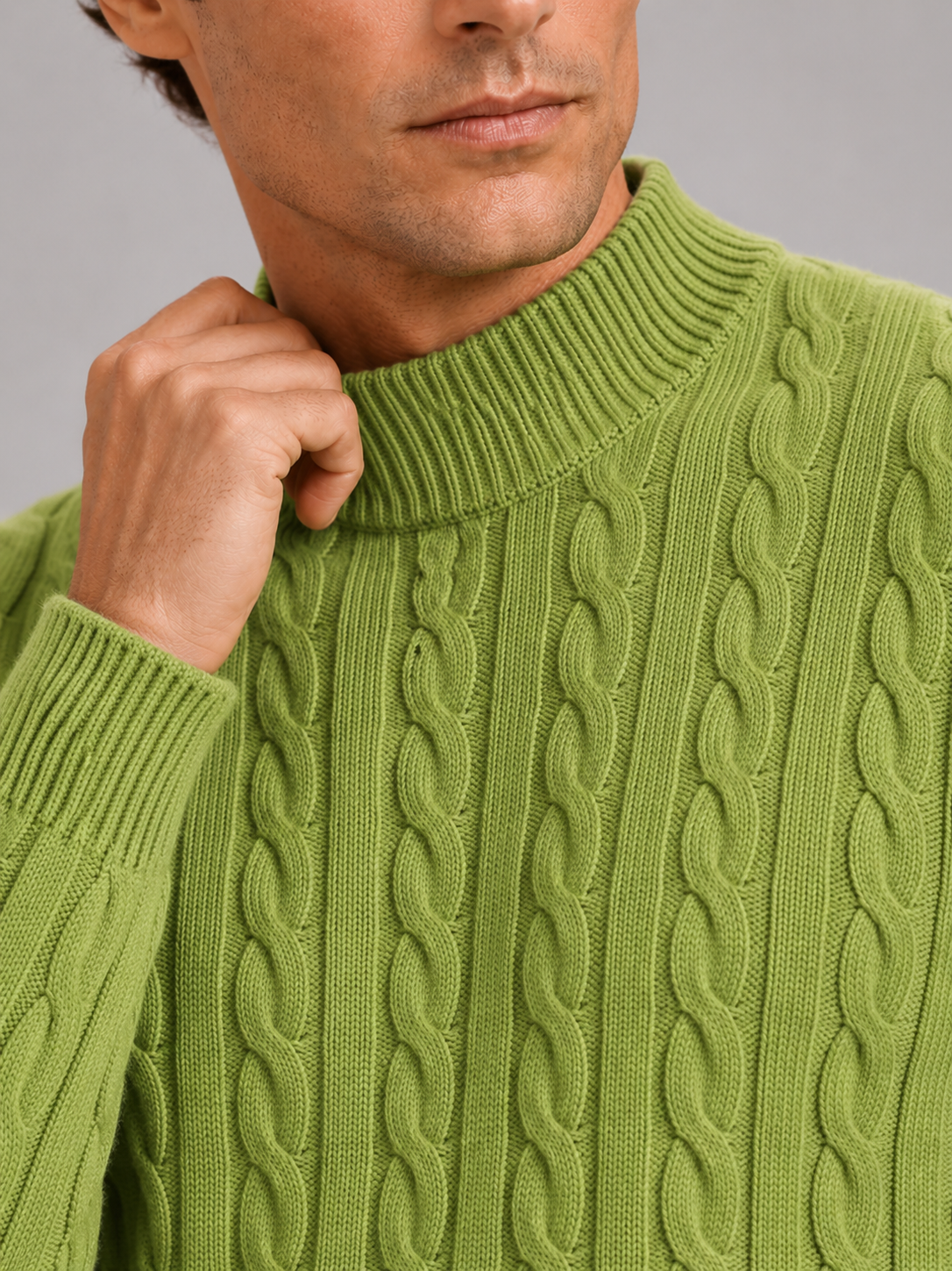 Close up of green wool cable knit sweater showing soft texture and mock neck detail