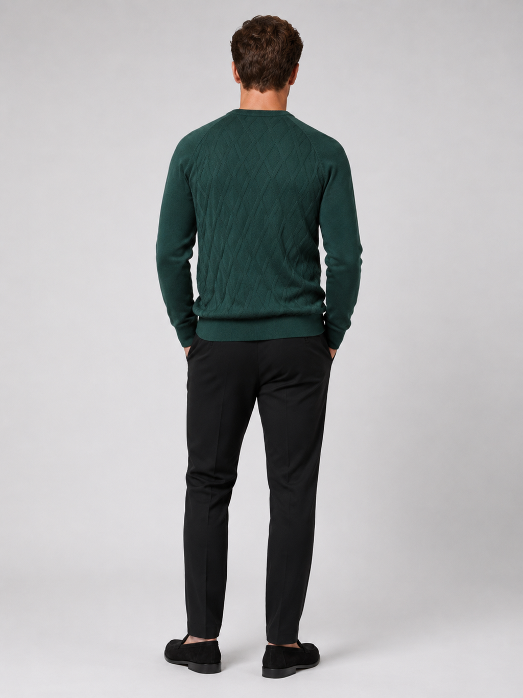 Back view of a man wearing a green argyle sweater showing the crew neck, long sleeves, and comfortable fit