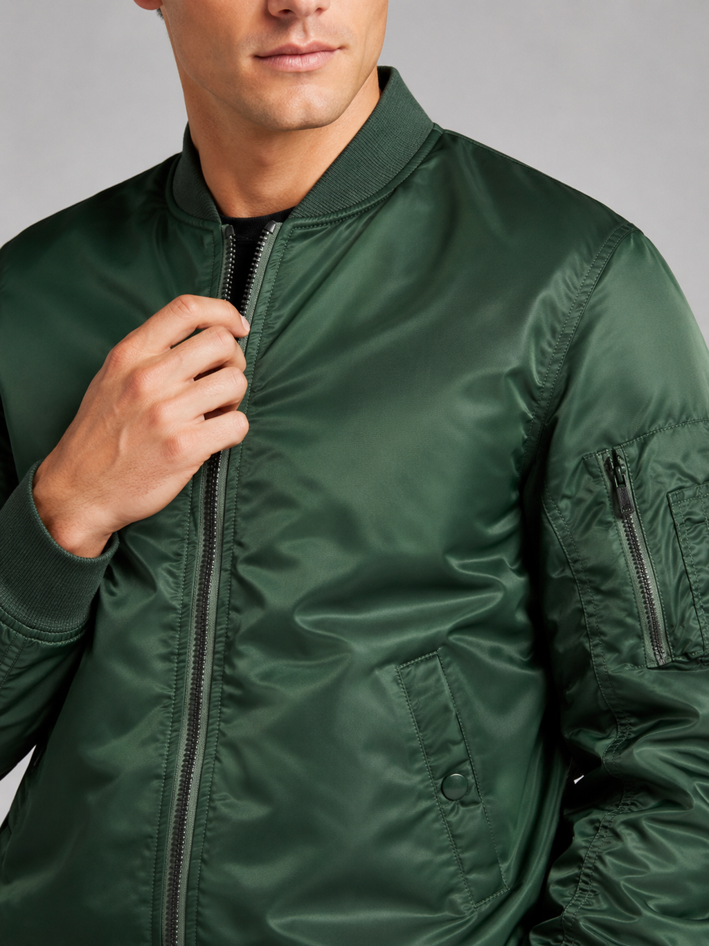 Close up of green bomber jacket showing lightweight windbreaker fabric and zip up front detail