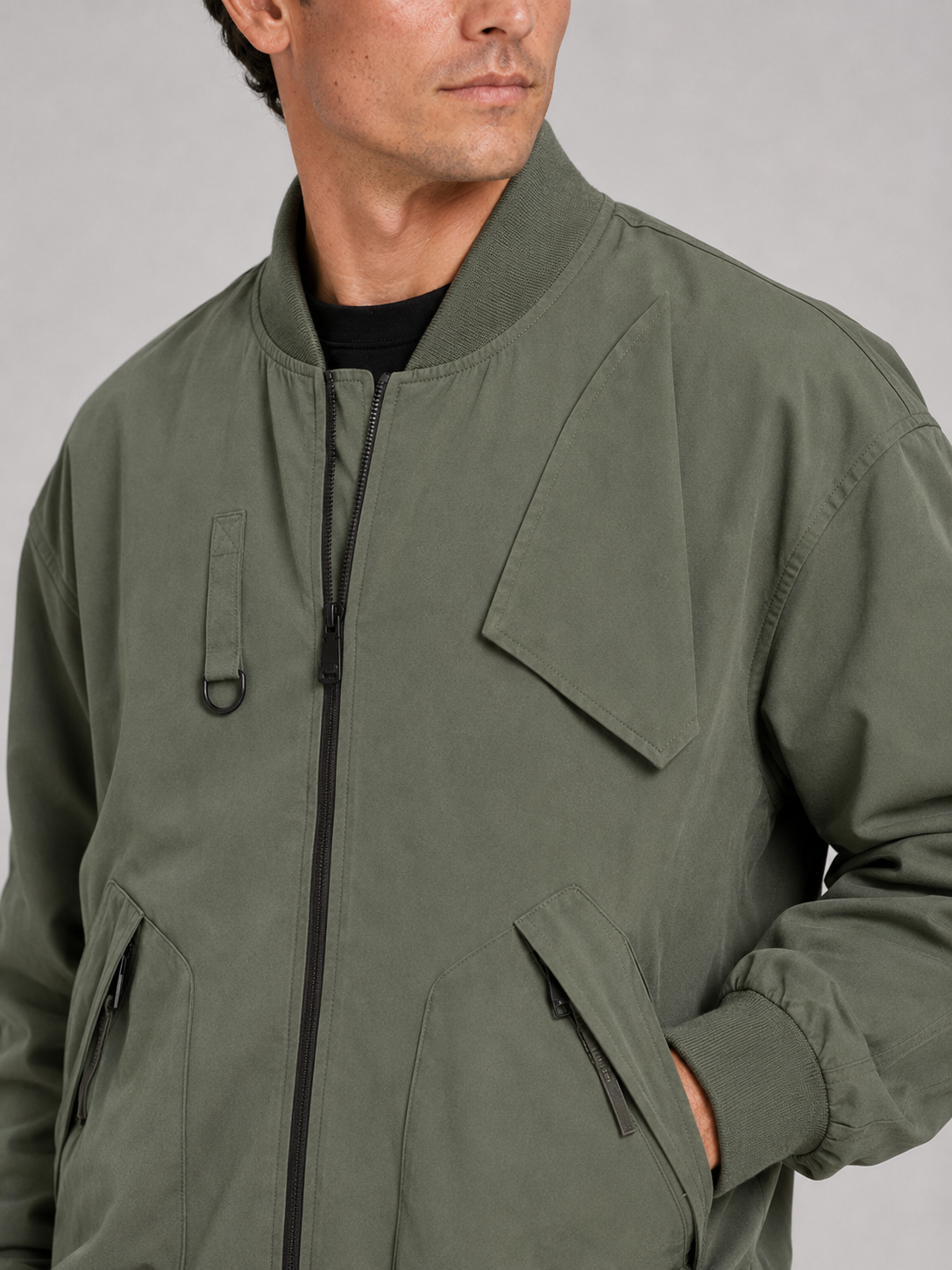 Close up of green bomber jacket showing durable fabric and ribbed collar detail