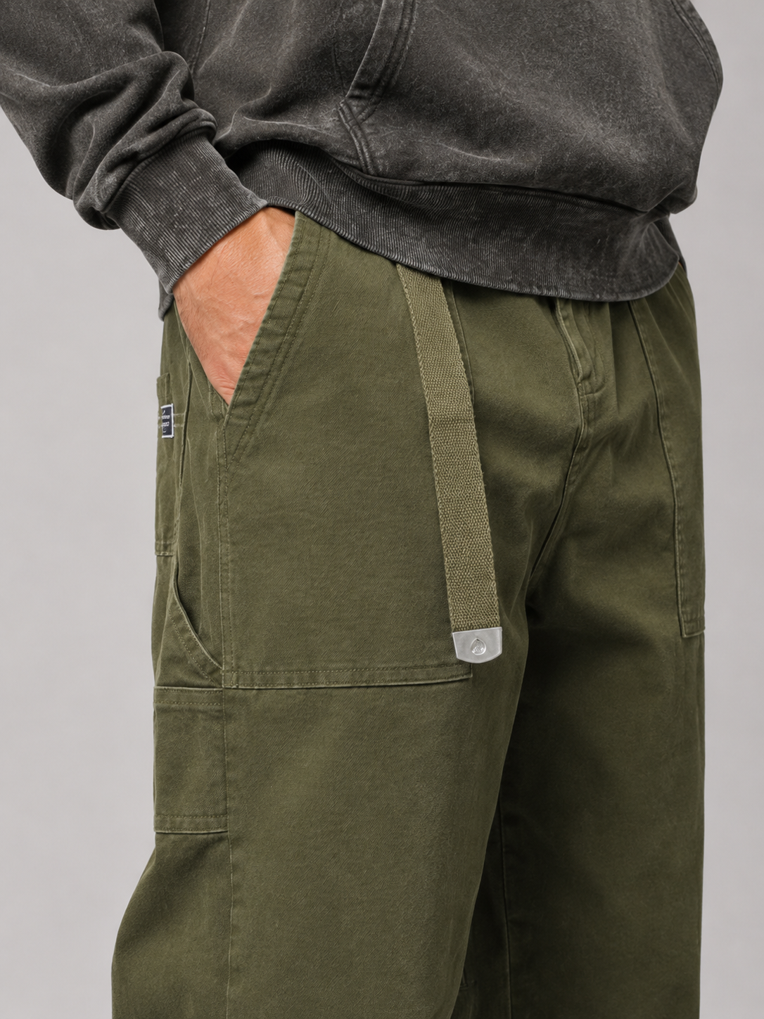 Close up of green cargo pants showing durable fabric texture and utility pocket detail