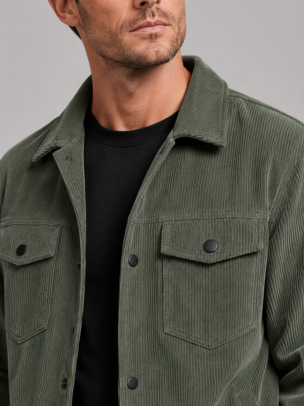 Close up of green corduroy jacket showing soft ribbed texture, classic lapel, and button front detail