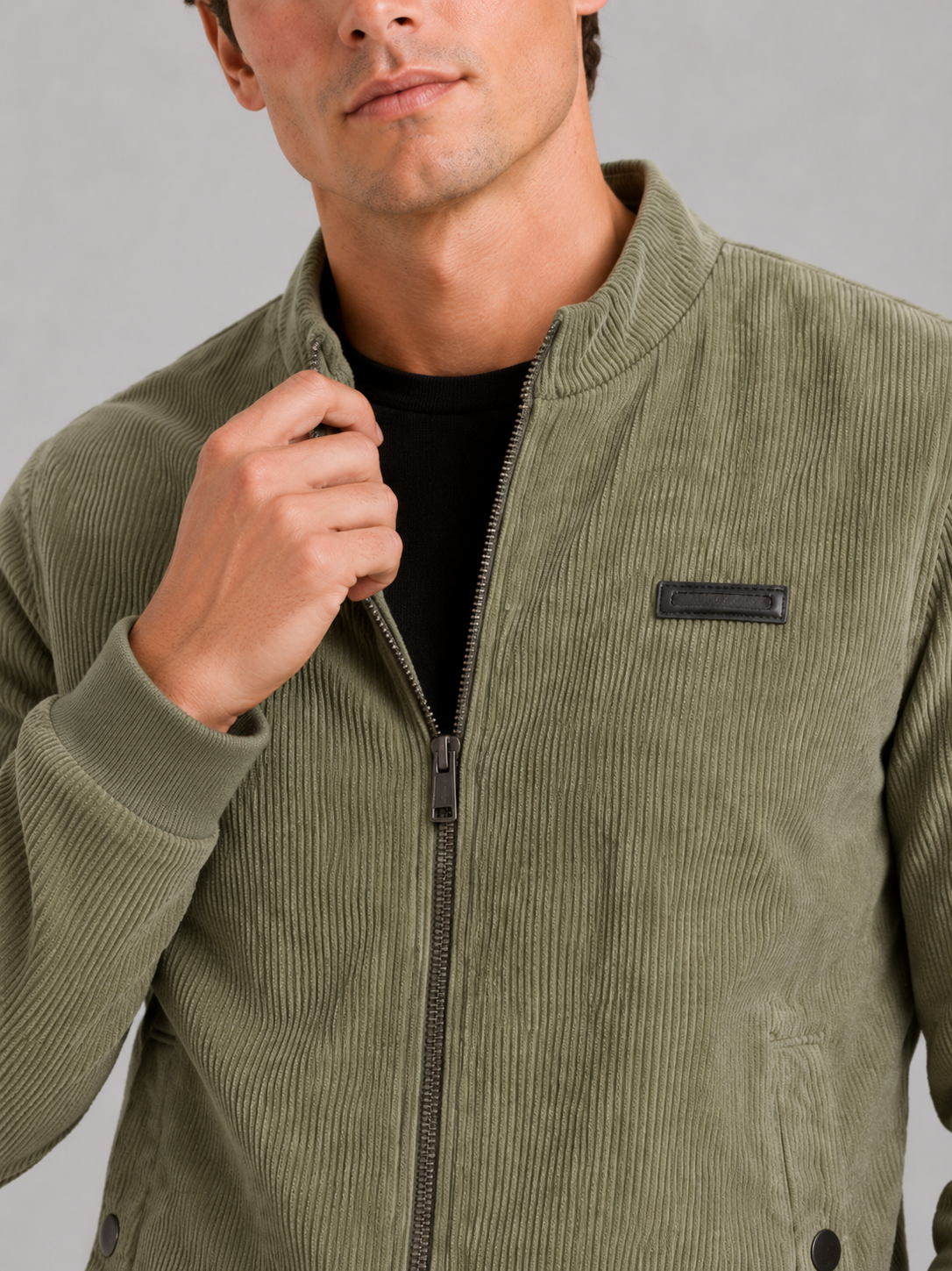 Close up of green corduroy workwear jacket showing padded cotton fabric and textured corduroy detail