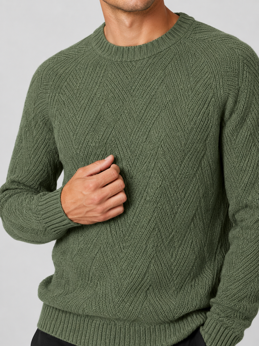 Close up of green knit sweater showing soft textured fabric and classic crew neck detail