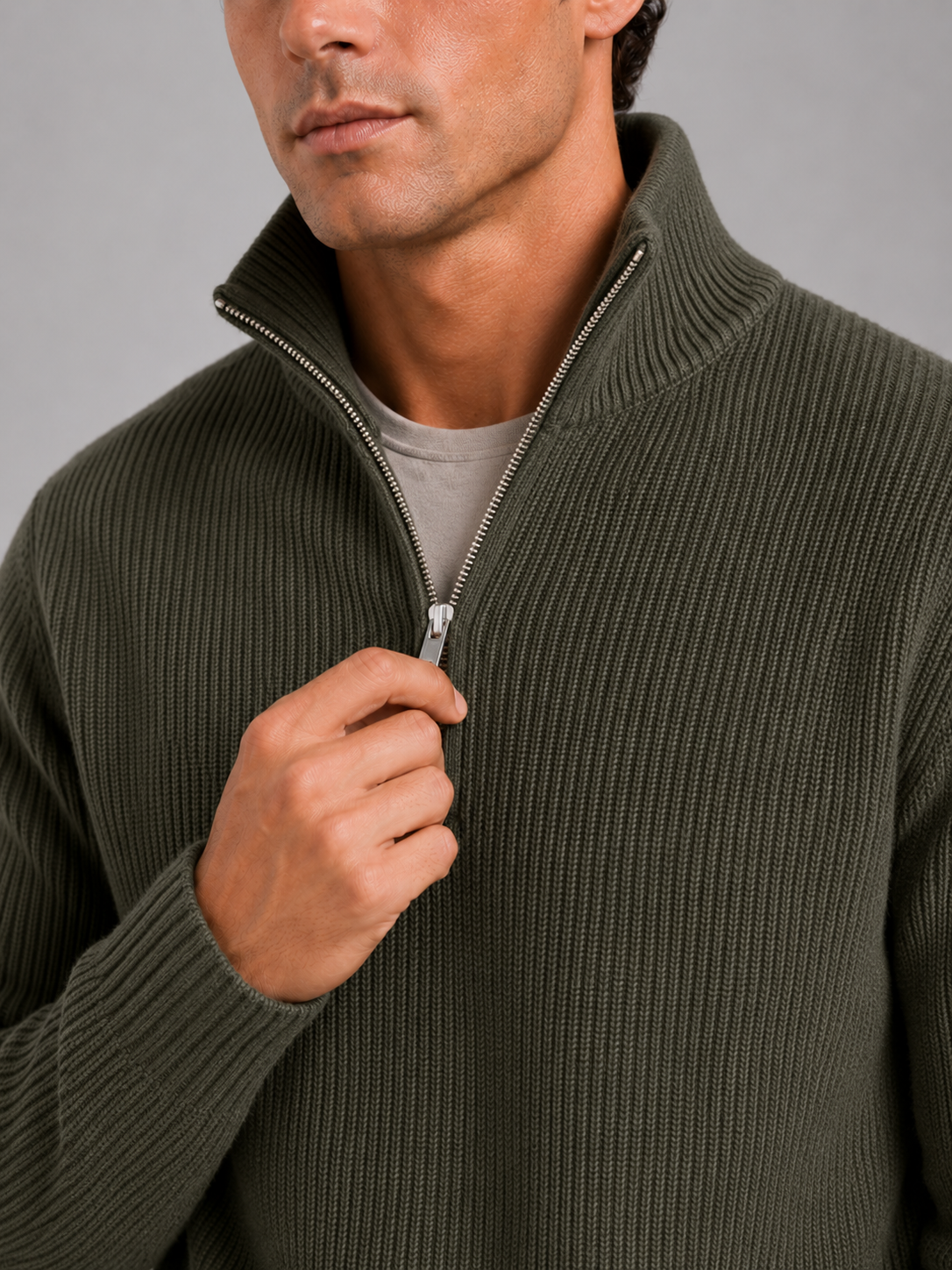 Close up of green half zip sweater showing thick knit texture and refined zipper detail