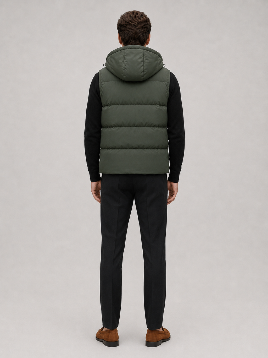 Man wearing a navy hooded puffer vest in a casual fall winter outfit for outdoor and everyday wear