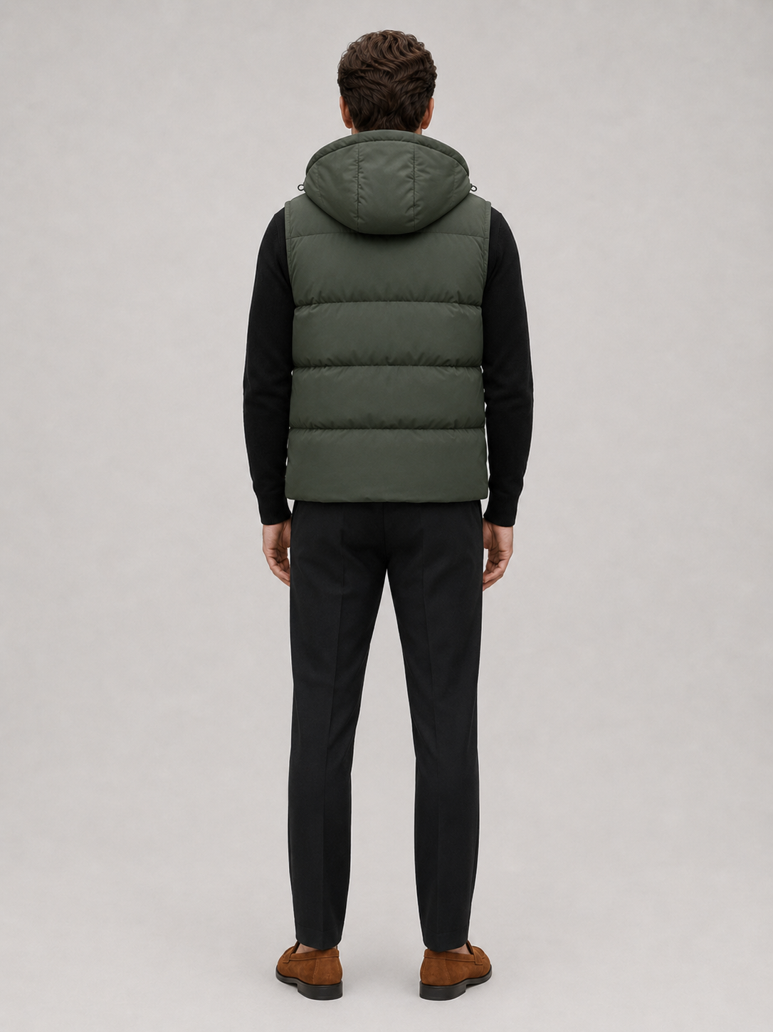Man wearing a navy hooded puffer vest in a casual fall winter outfit for outdoor and everyday wear