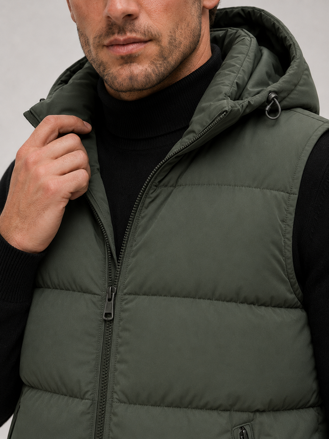 Man wearing a navy hooded puffer vest in a casual fall winter outfit for outdoor and everyday wear