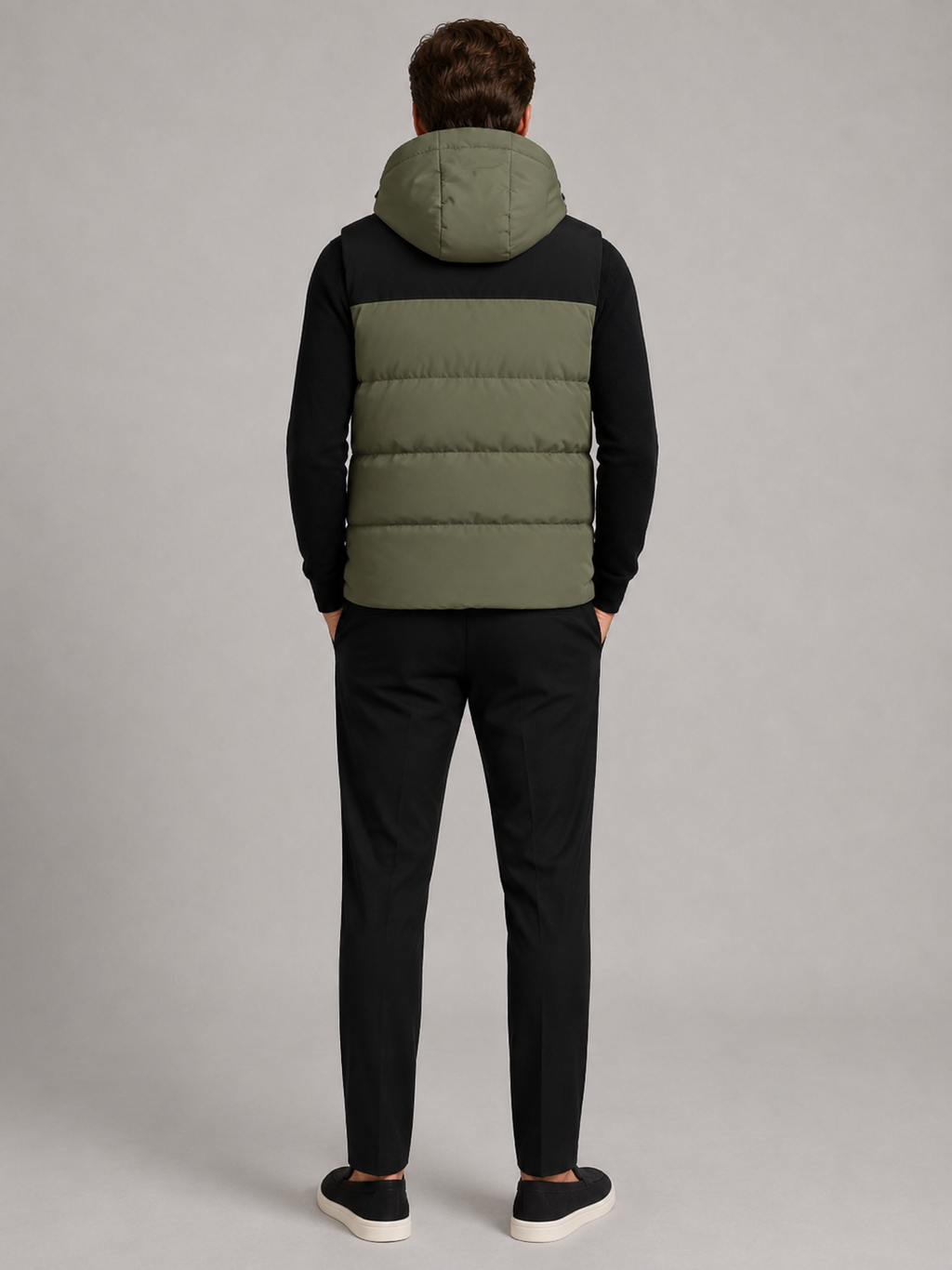 Back view of a man wearing a green hooded puffer vest showing the attached hood, padded construction, sleeveless cut, and comfortable fit