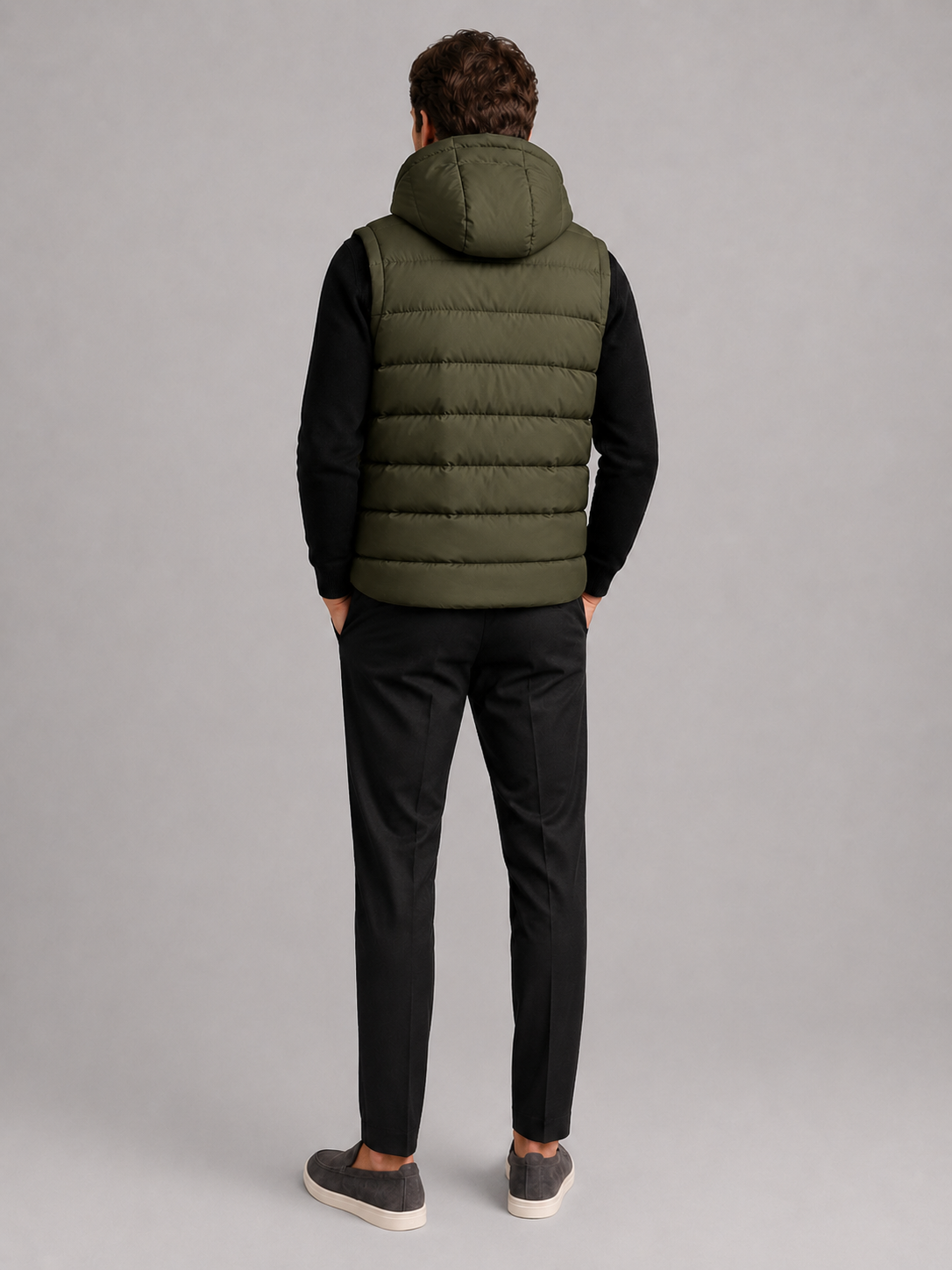 Back view of a man wearing a green hooded puffer vest showing the attached hood, padded construction, sleeveless cut, and comfortable fit