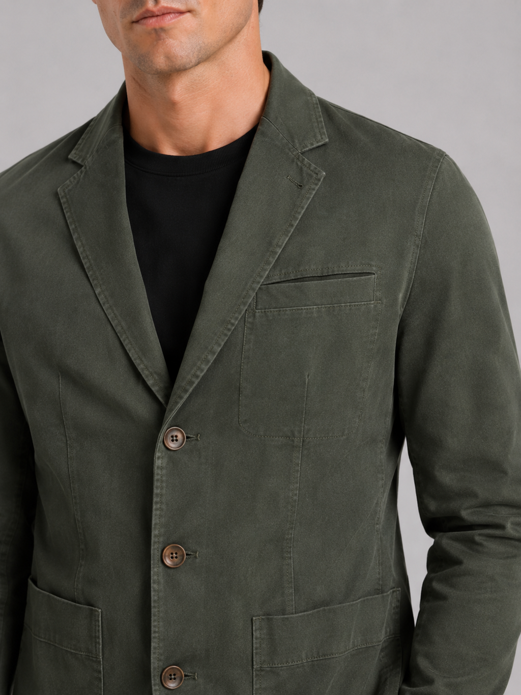 Close up of green washed cotton blazer jacket showing soft texture and tailored lapel detail