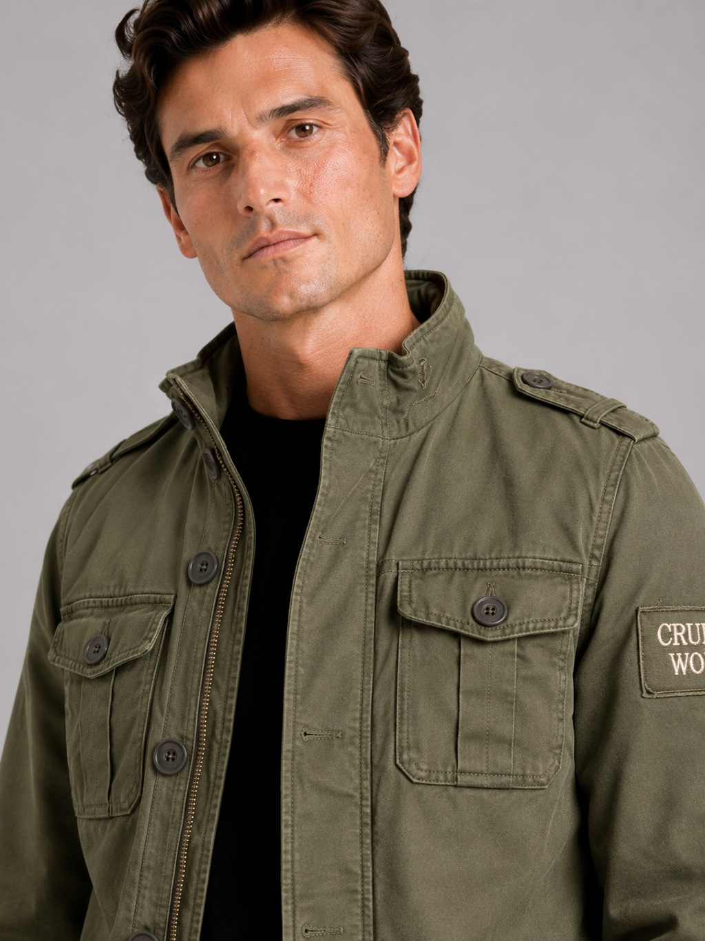 Close up of green military cargo jacket showing durable heavyweight cotton fabric and utility pocket detail