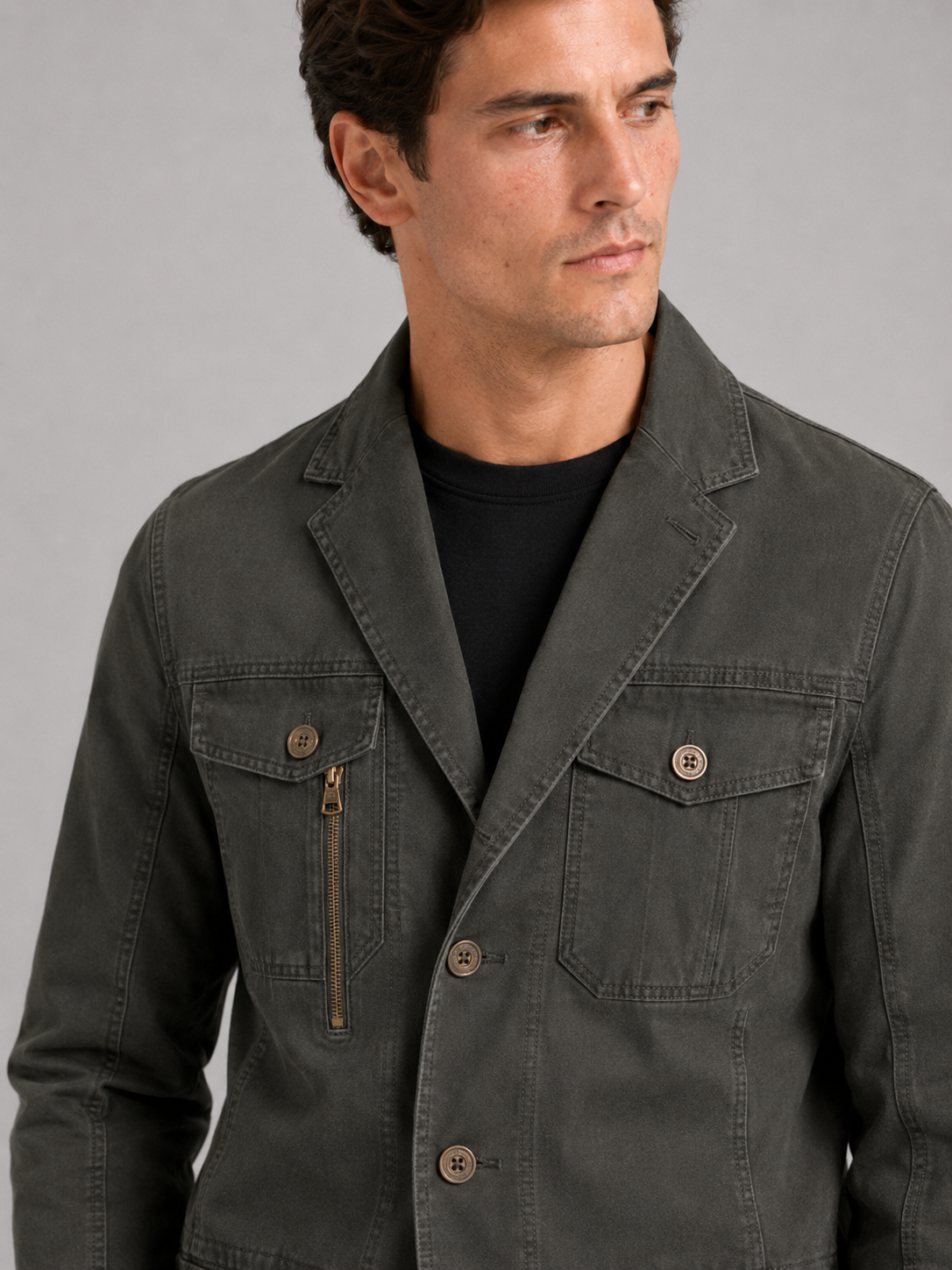 Close up of green military jacket showing durable cotton fabric and functional multi pocket detail