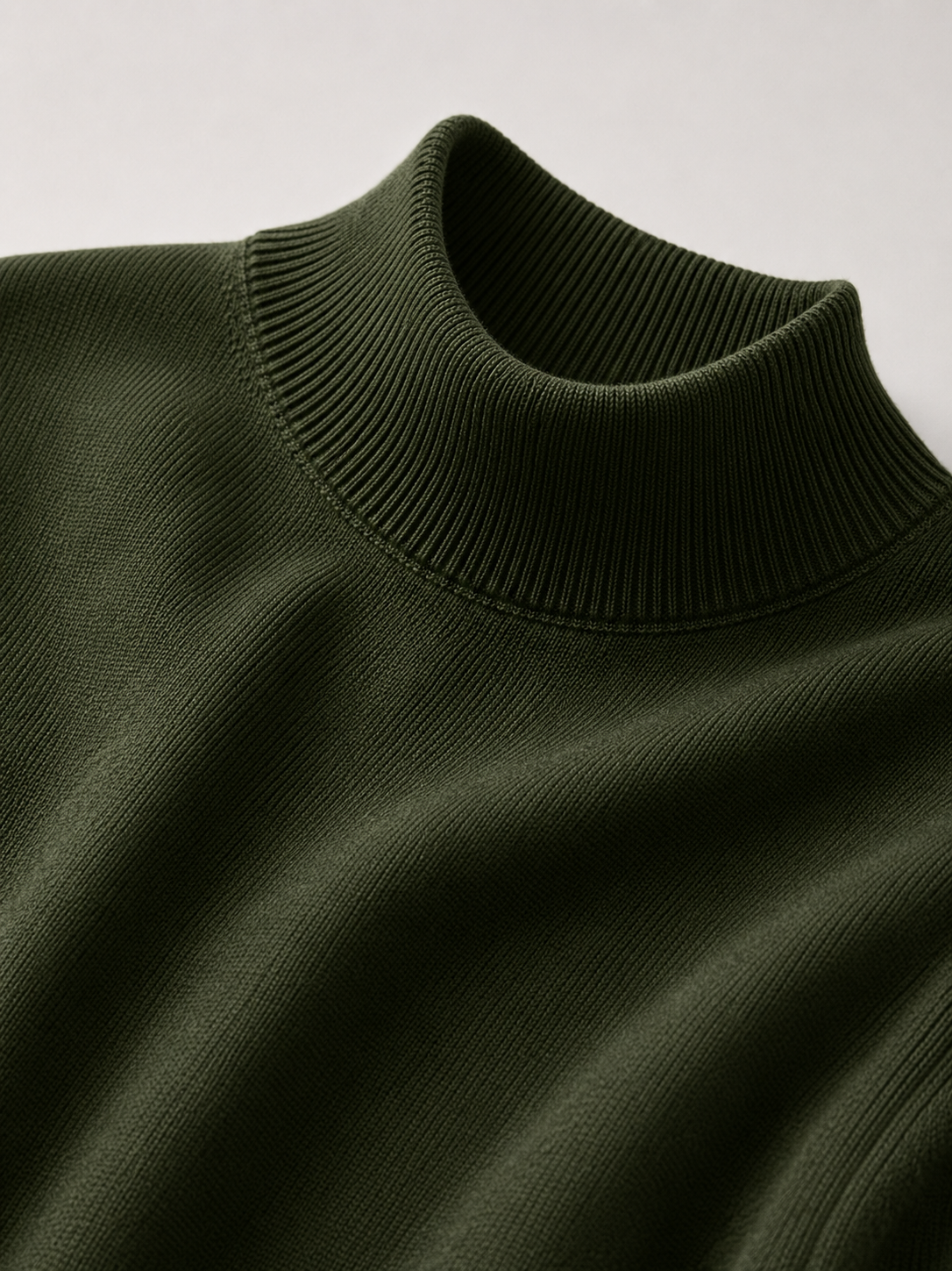 Close up of green mock neck sweater showing soft knit texture and refined collar detail
