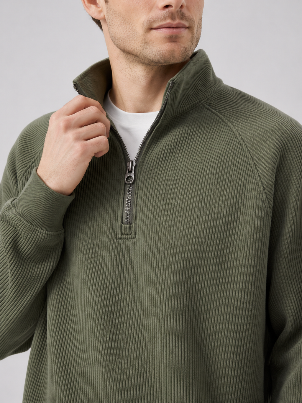 Close up of green quarter zip sweater showing soft knit texture and stand collar zipper detail
