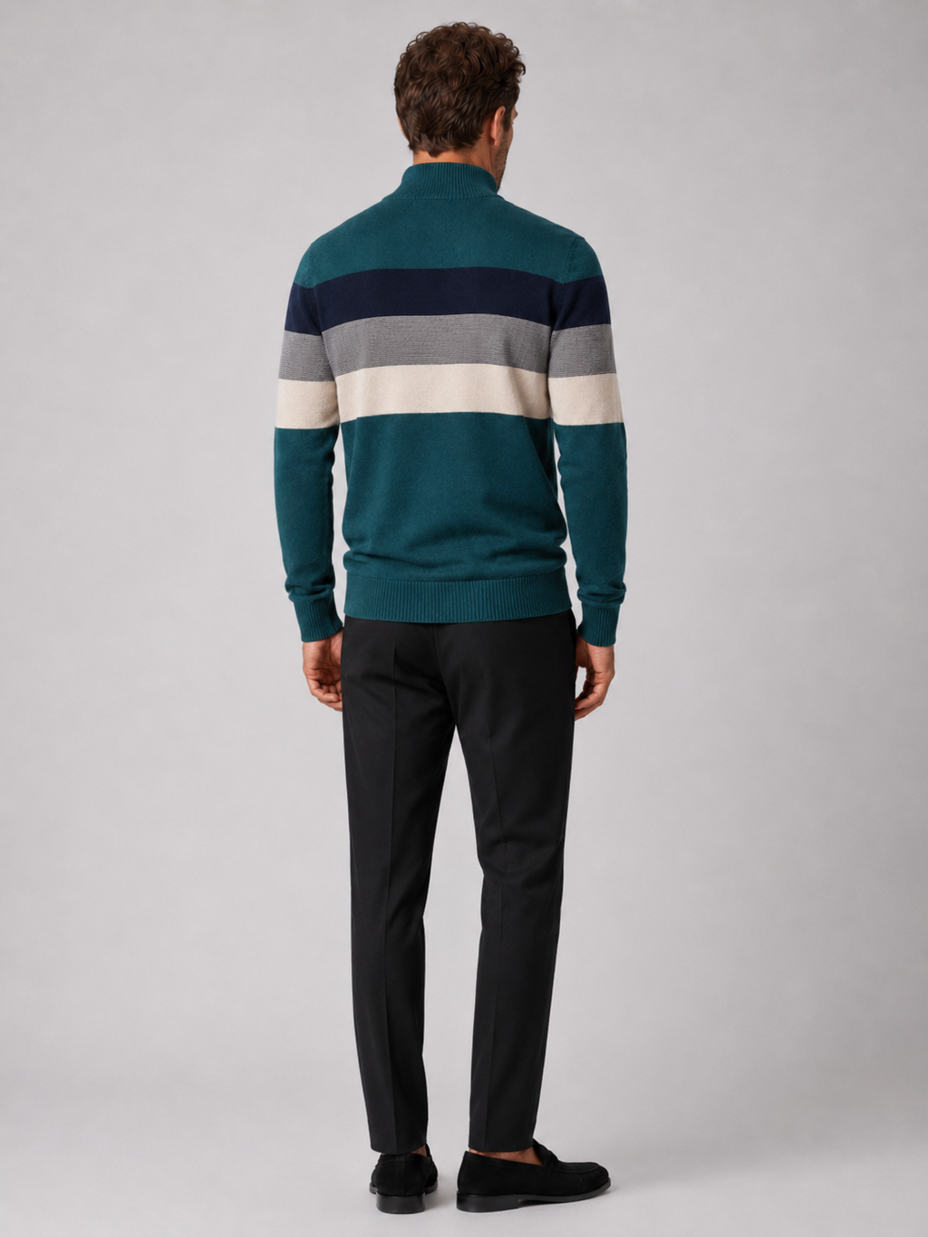 Back view of a man wearing a green cotton quarter zip sweater showing the patchwork design and relaxed fit