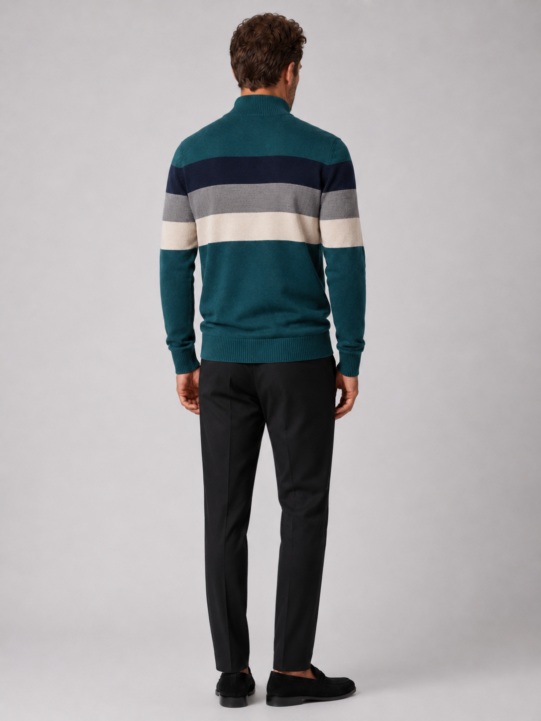 Back view of a man wearing a green cotton quarter zip sweater showing the patchwork design and relaxed fit