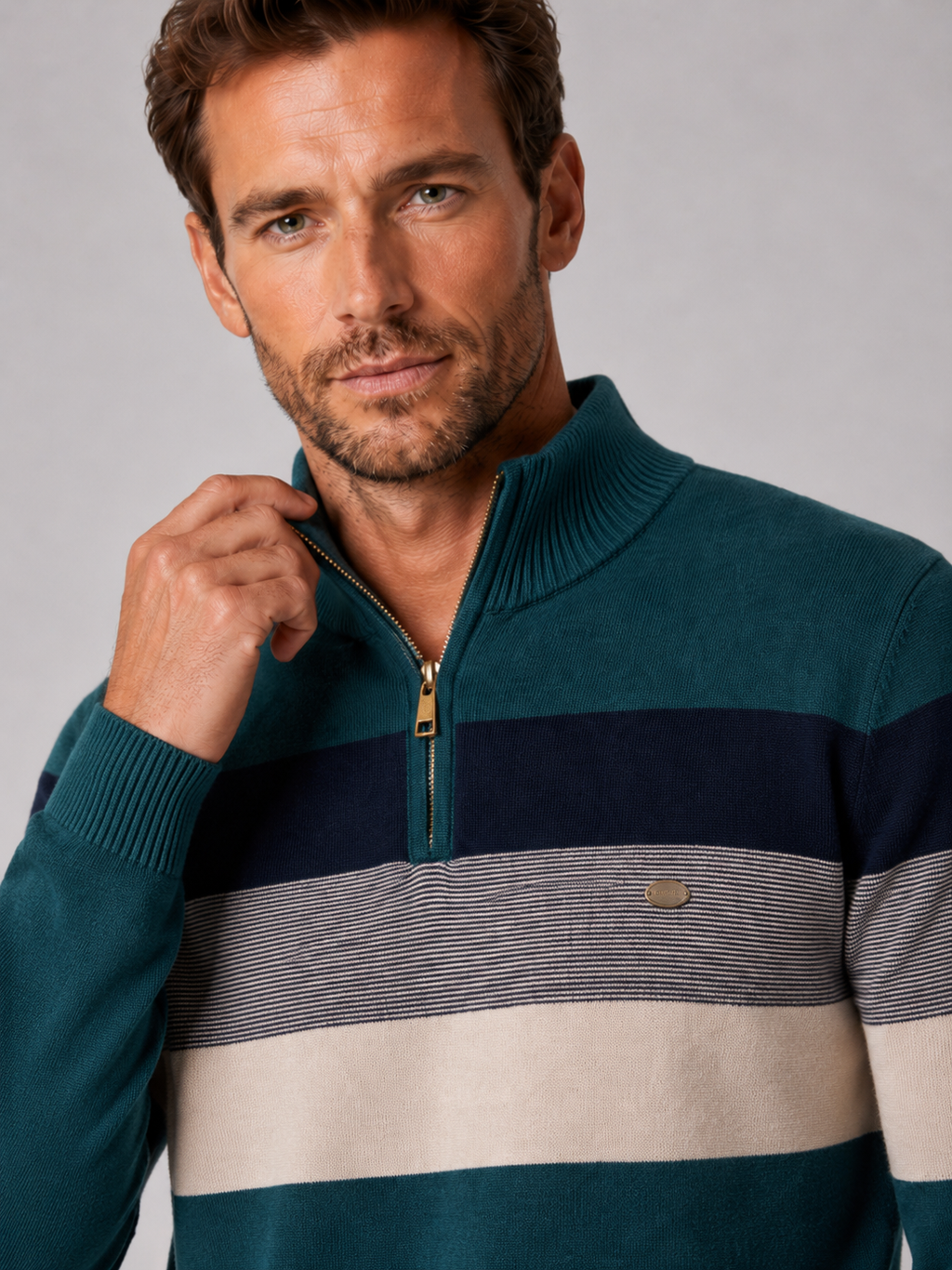 Close-up of a green patchwork quarter zip sweater showing the cotton knit texture, mock neck, zipper, and stitching