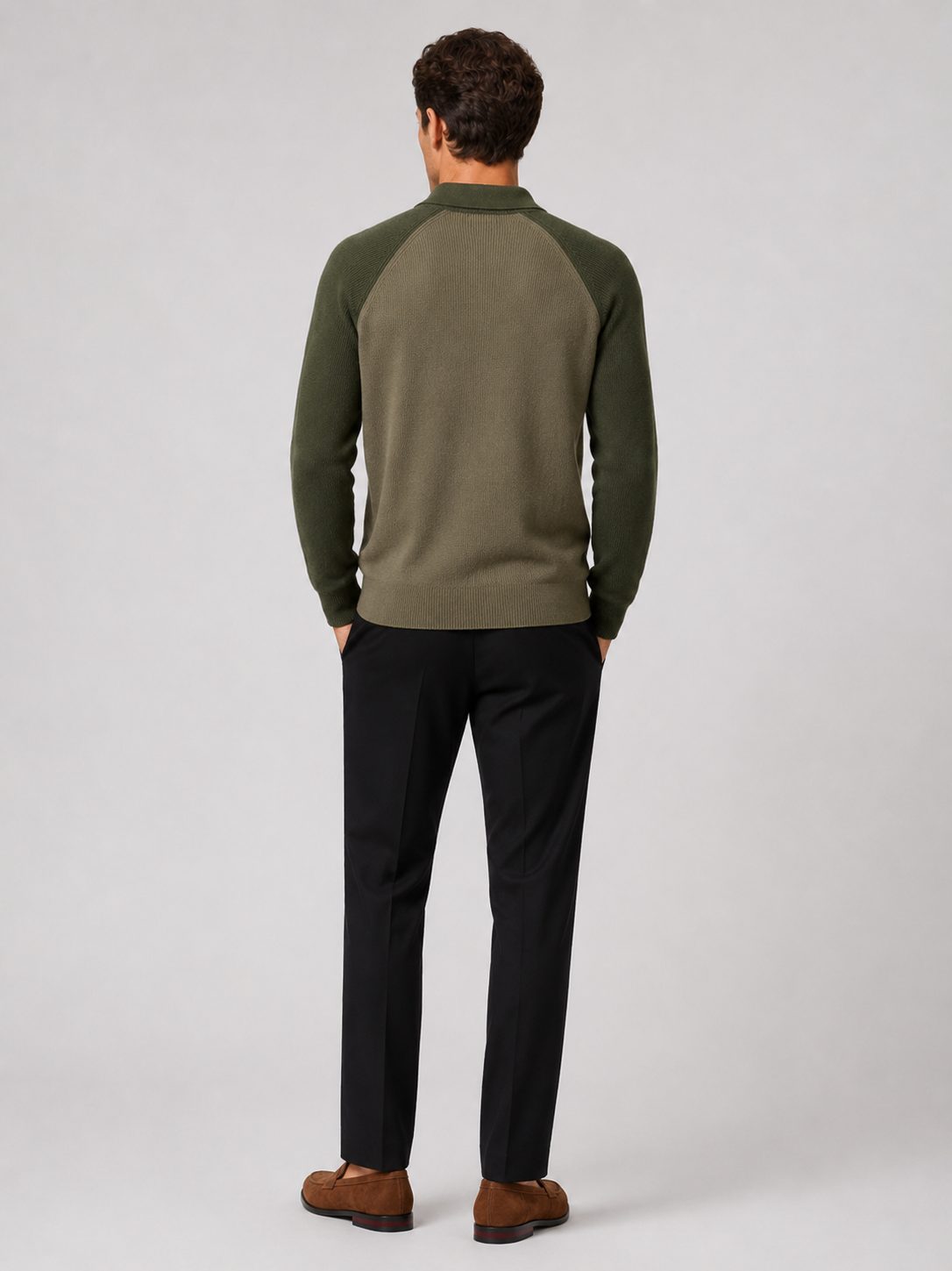 Back view of a man wearing a green quarter zip knit polo sweater showing the slim fit and long sleeves