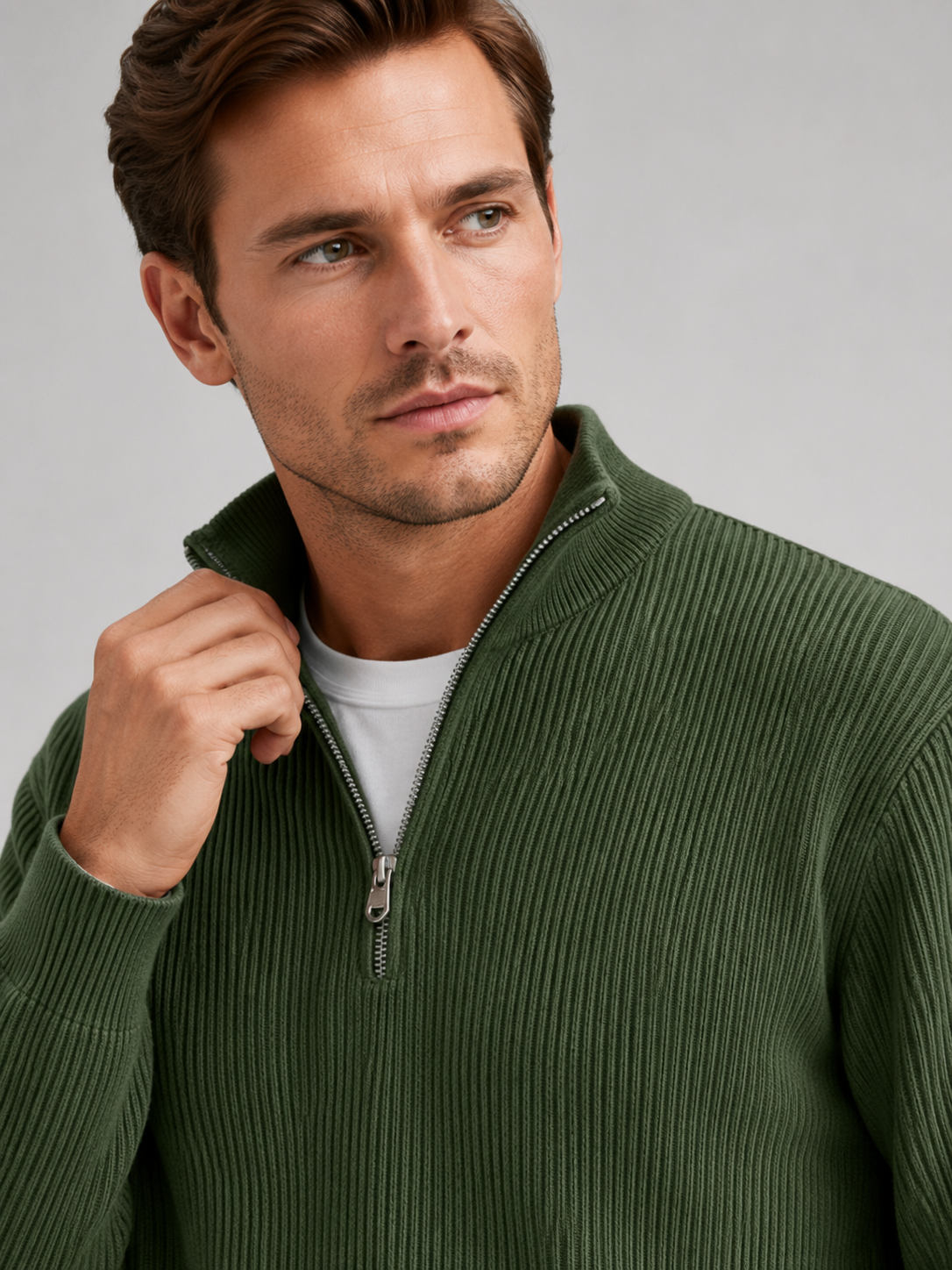 Close up of green quarter zip sweater showing ribbed knit texture, stand collar, and zipper detail