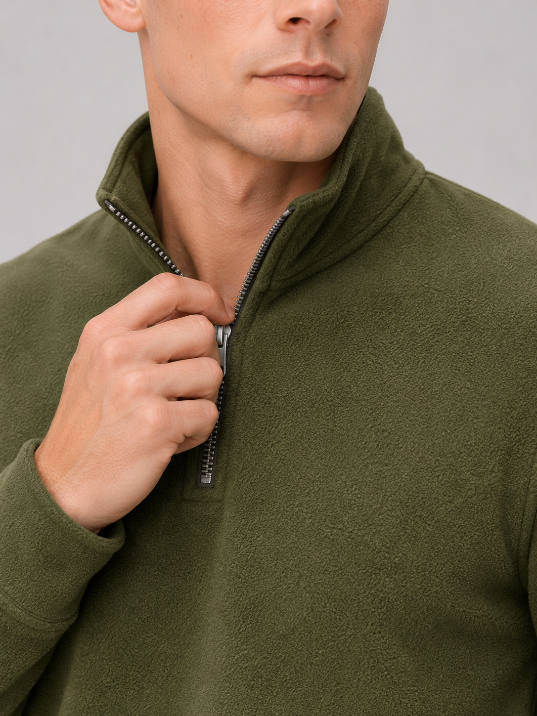 Close up of green fleece pullover showing soft thermal fabric and quarter zip mock neck detail