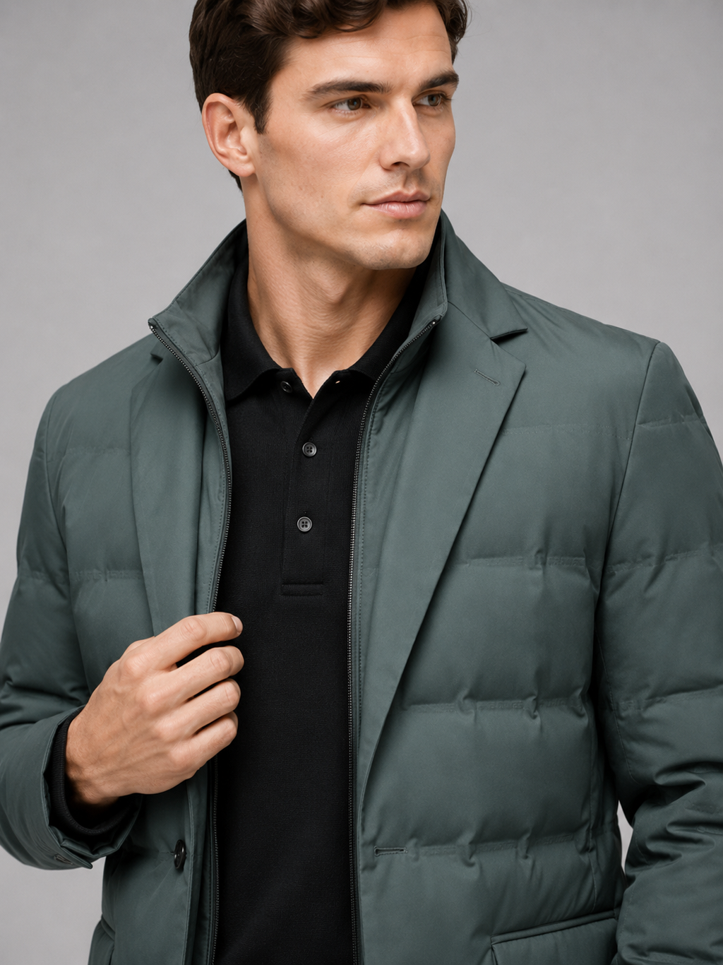 Close up of green quilted jacket showing insulated stitching, detachable stand collar, and zip front detail