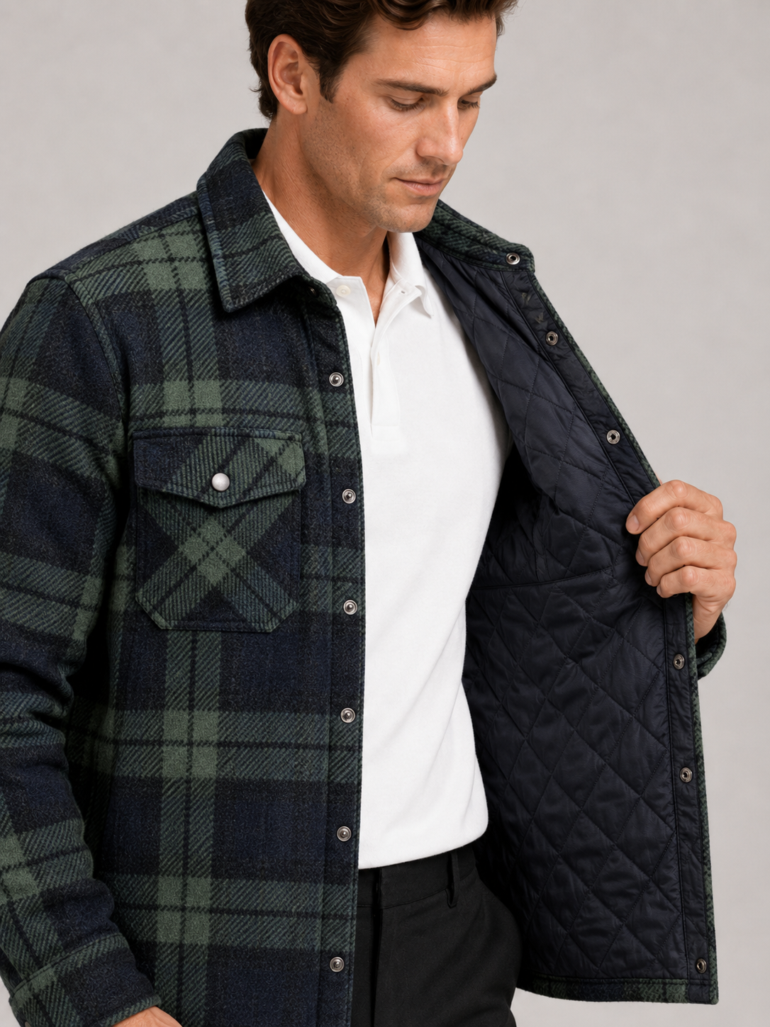 Close up of green quilted jacket showing plaid flannel lining, quilted stitching, and durable fabric detail