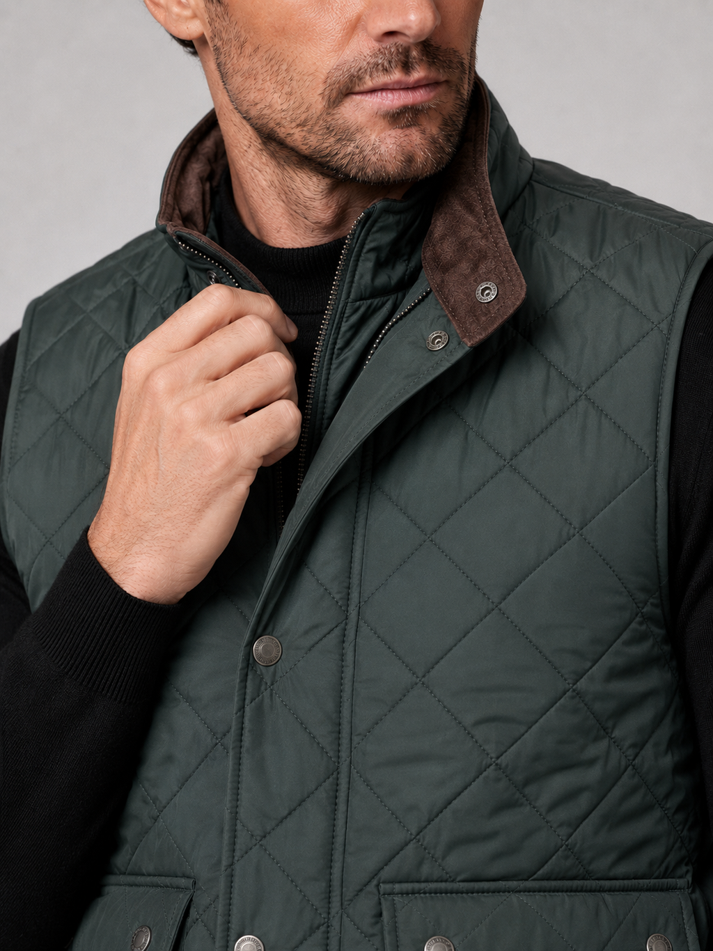 Close-up of a green quilted vest showing the stitched pattern, polo collar, thick padding, front closure, utility pockets, armholes, and reinforced seams