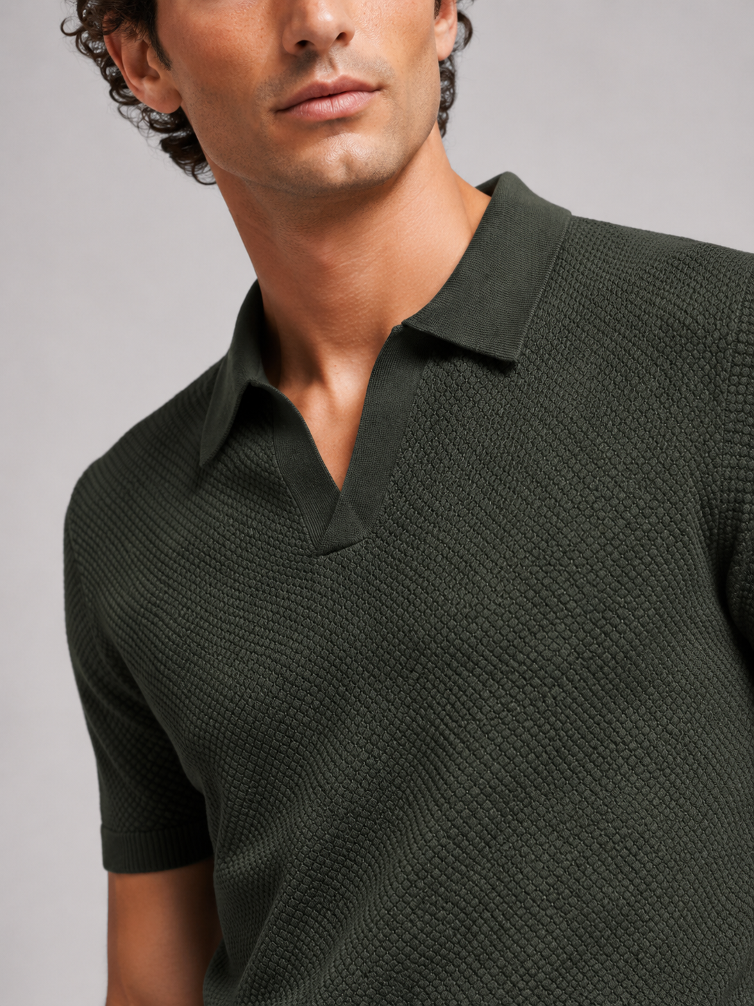 Close up of green knit polo showing soft breathable stretch fabric and refined collar detail