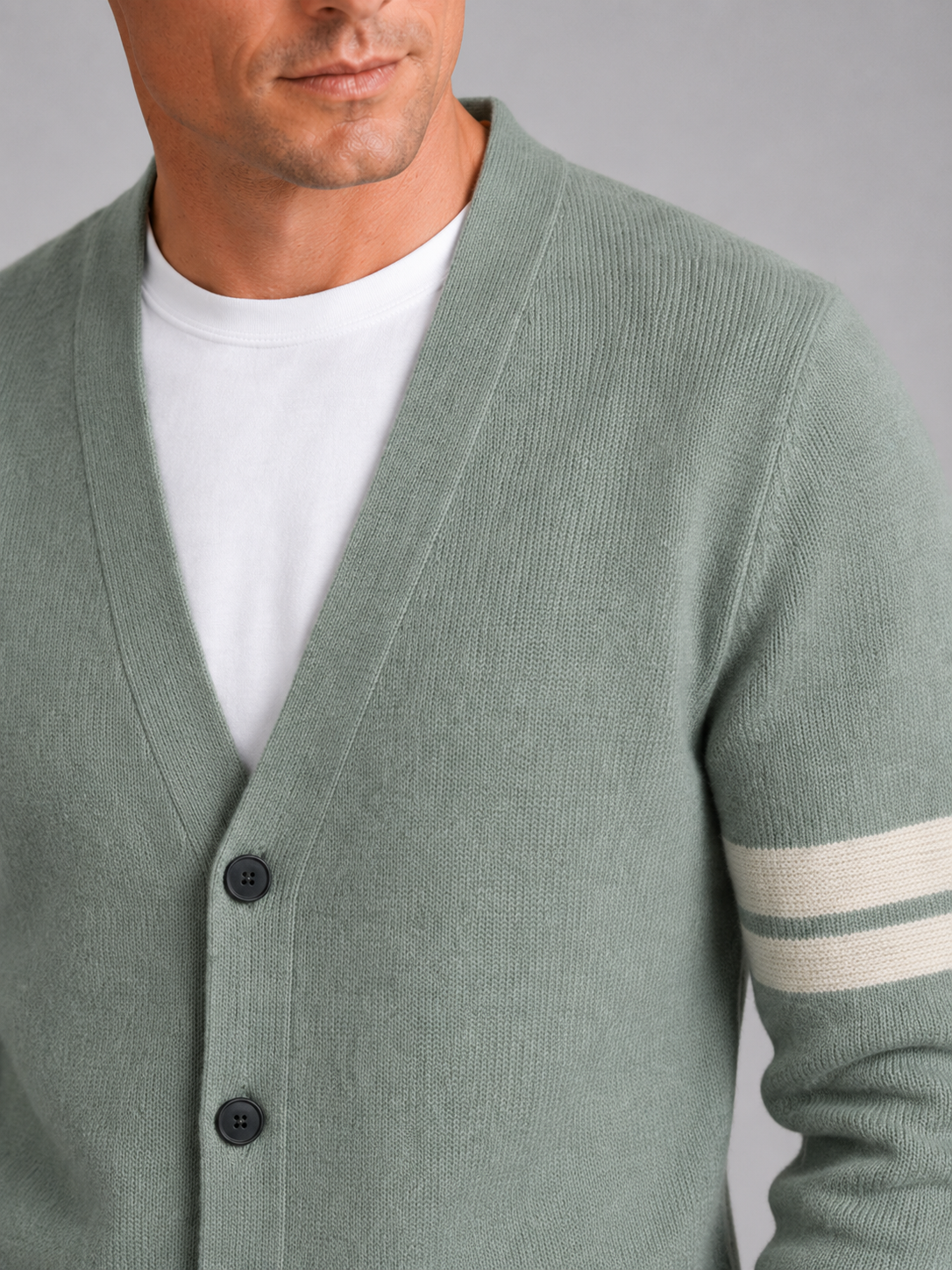 Close up of green striped cardigan showing soft knit texture and color block pattern detail