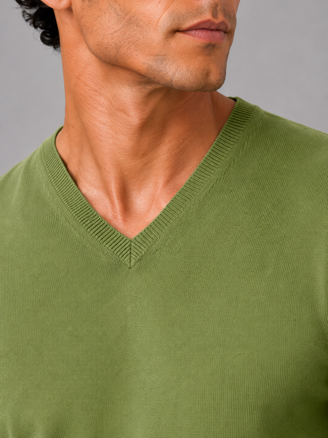 Close up of green knit sweater showing soft lightweight fabric and refined v neck detail
