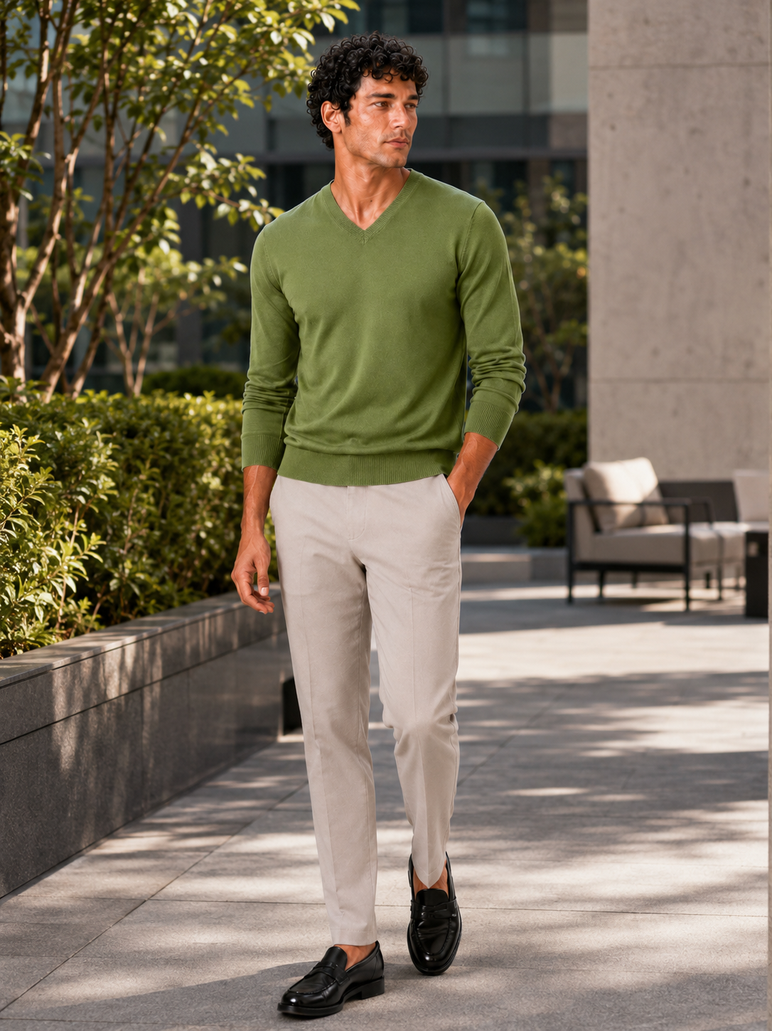 Man styling green v neck knit sweater in a relaxed fall lifestyle outfit