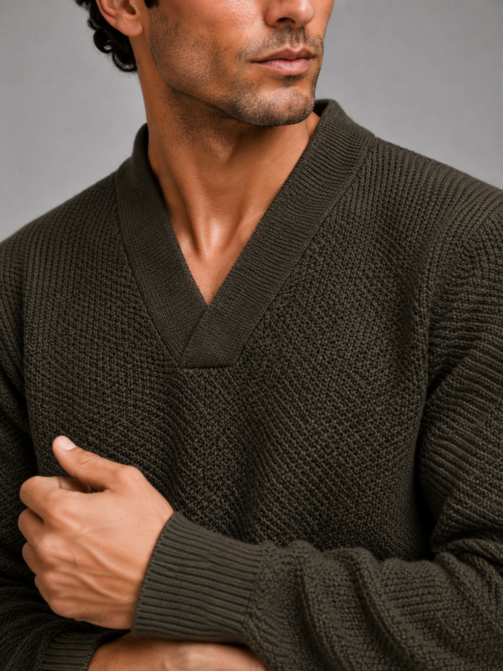 Close up of army green knit sweater showing thick warm fabric and refined v neck detail