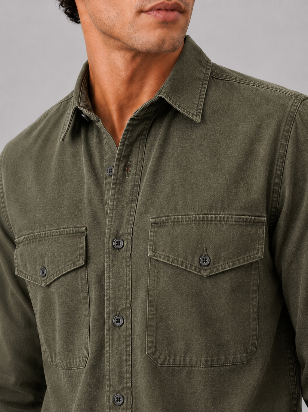 Close up of green washed cotton work shirt showing soft fabric texture and pocket detail