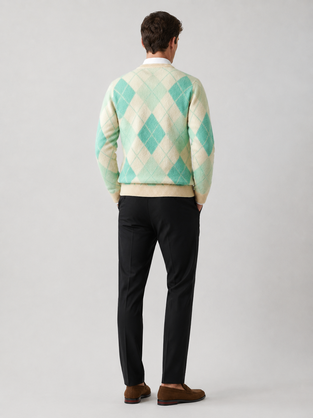Back view of a man wearing a green wool argyle sweater showing the crew neck, long sleeves, thick knit fabric, and comfortable fit
