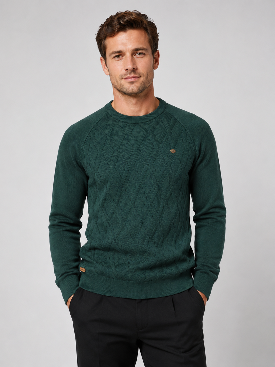 Front view of a man wearing a green argyle crew neck sweater with long sleeves and a warm knit pattern