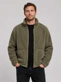 Front view of a man wearing a green full zip fleece jacket with a stand collar, loose fit, long sleeves, and warm fall winter design